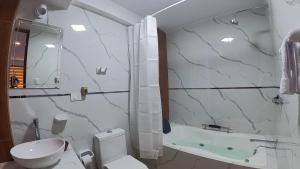 a bathroom with a shower and a toilet and a tub at Hotel Rosa Mistika Inn in Arequipa