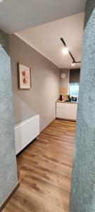 an empty room with a kitchen and a hard wood floor at Mini Cozy Spot in Żagań +8 photos