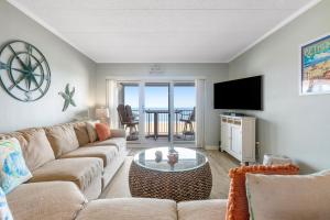 a living room with a couch and a flat screen tv at Pelican Beach 204 in Ocean City