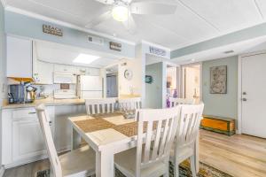 a kitchen and dining room with a table and chairs at Pelican Beach 204 in Ocean City