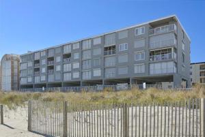 a building on the beach with a fence in front of it at Pelican Beach 304 in Ocean City