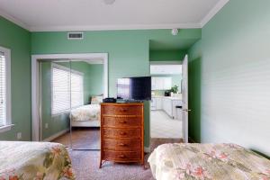 a bedroom with green walls and a dresser with a mirror at Sunset Bay III 313 in Ocean City +18 photos