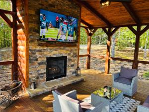 a screened in porch with a fireplace and a tv at Above Expectations-New Exterior-Sleeps 8-Hot Tub-Games Galore-Nature in Morganton
