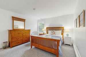 a bedroom with a bed and a dresser and a mirror at Cozy Corner in Edgartown