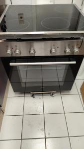 a stove top oven with a skateboard underneath it at Im Herzen City Kiel 1 Zi Whg pure Gemütlichkeit, eigener Parkplatz,10 m Fußweg zur Universität zu Kiel, 5 min zur Uniklinik, Ostsee, in Kiel +27 photos