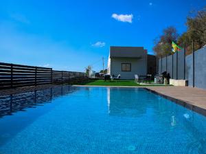 a large blue swimming pool in front of a house at Vista royal golan in Ein Kinya