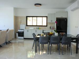 a kitchen with a table and chairs in a room at Vista royal golan in Ein Kinya