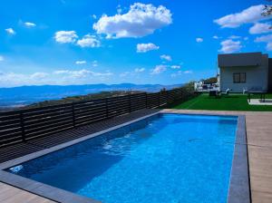 a large blue swimming pool on top of a house at Vista royal golan in Ein Kinya