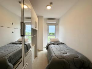 a bedroom with two beds and a window at Apartamento en Luque cerca a Asunción con Piscina y cancha de pádel 812 in Luque