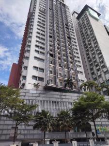 a tall white building with trees in front of it at Tarragon Family Suite Apartment in Kuala Lumpur