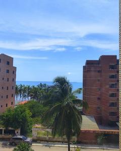 een palmboom op een parkeerplaats naast een gebouw bij Apartamento con vista al Mar bien ubicado 