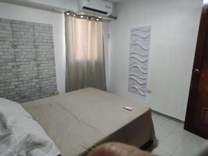 een slaapkamer met een bed in een kamer met een raam bij Apartamento con vista al Mar bien ubicado 