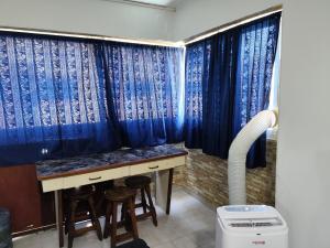 een badkamer met blauwe gordijnen en een bureau en krukken bij Apartamento con vista al Mar bien ubicado 