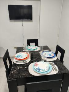 een tafel met borden en keukengerei erop bij Apartamento con vista al Mar bien ubicado  +11 foto's