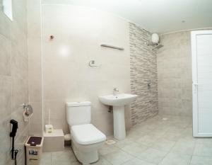 a bathroom with a toilet and a sink at Marhaba Tausi Nyali in Mombasa