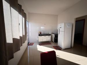 a kitchen with a white refrigerator and a stove at Casinha Aconchegante in Primavera do Leste +5 photos