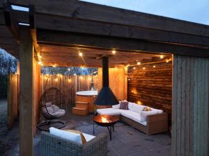 d'une terrasse avec des canapés, une table et des lumières. dans l'établissement Homestead Gardens by Wigwam Holidays, à Filby