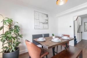 un comedor con mesa, sillas y una planta en Central 2-Bed Modern Home with Garage, en Cheltenham