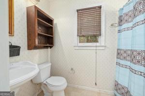 een badkamer met toilet, wastafel en douche bij Clifford Guest House in Loganville