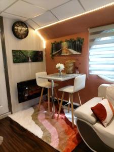 a living room with a table and chairs and a clock at Péniche Morgane 2 chambre d'hôtes in Cambrai