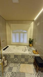 e bagno con vasca e pavimento piastrellato. di Chale raiz e conforto a São Francisco do Sul