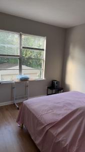a bedroom with a bed and a desk and two windows at Mike's home in Texas City