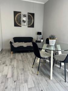 een woonkamer met een glazen tafel en een bank bij Favoloso trilocale in Monza