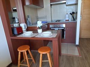 a kitchen with a counter with two stools at Departamento Salar in Calama