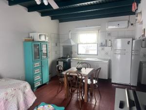 a kitchen with a table and chairs and a refrigerator at La Casita in Neuquén