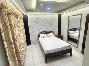 a small bedroom with a bed and a mirror at Hotel tower one in Guayaquil