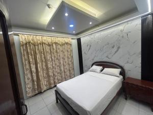 a bedroom with a bed and a stone wall at Hotel tower one in Guayaquil