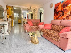 Una sala de estar con un sofá y una mesa de cristal. en PLAYA DEL CURA - Spacious Beachside Apartment, en Playa del Cura