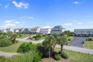 an apartment complex with palm trees and a street at Wahoo Waves in Emerald Isle