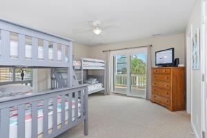 a bedroom with two bunk beds and a sliding glass door at Wahoo Waves in Emerald Isle