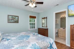 a bedroom with a bed and a ceiling fan at You, Me and The Sea in Cedar Point