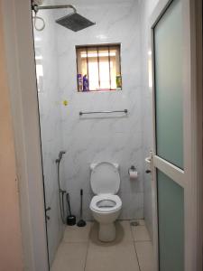 Un baño con inodoro y ventana. en Bnb, en Mombasa