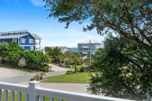 a view of some houses and a white fence at Sweet Dreams Beach House in Emerald Isle