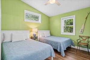 two beds in a room with green walls at Sweet Dreams Beach House in Emerald Isle