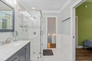 a bathroom with a shower and a sink and a mirror at Sweet Dreams Beach House in Emerald Isle +33 photos