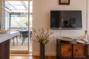 a living room with a flat screen tv on a wall at Waters Edge by Waiheke Pure in Waiheke Island