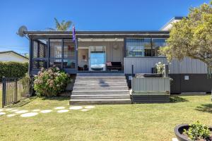 a house with a flag on the front of it at Waters Edge by Waiheke Pure in Waiheke Island