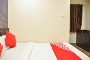 a bedroom with a bed with red pillows on it at Super Collection O by OYO De Sivalika Boutique Near Dakshineswar Kali Temple in Kolkata