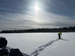 a person is cross country skiing on a frozen lake at Lapland Lakefront Villa - Winter Wonderland in Ranua