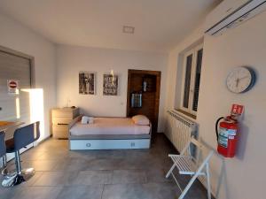 a bedroom with a bed and a desk and a clock at La dimora del viaggiatore in Gallarate
