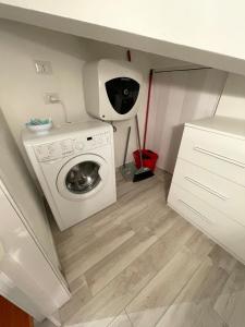 a laundry room with a washing machine under a counter at Lovely apartment near the beach in Follonica