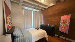 a bedroom with a bed and a brick wall at ROOM IN WILLIAMBURG IN A 2BEDROOMS APt in Brooklyn