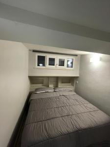 a bed in a small room with two windows at Lovely apartment near the beach in Follonica +23 photos