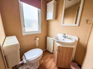a small bathroom with a toilet and a sink at 4 Berth Caravan For Hire At Sunkist Holiday Park Near Skegness Ref 42084S in Anderby +16 photos