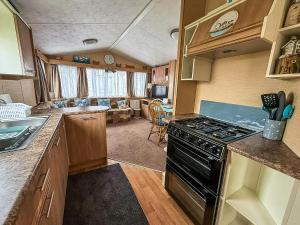 a kitchen with a stove and a living room at 4 Berth Caravan For Hire At Sunkist Holiday Park Near Skegness Ref 42084S in Anderby