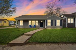a house with two blue chairs in the front yard at Baytown Getaway Patios BBQ Family-Friendly in Baytown